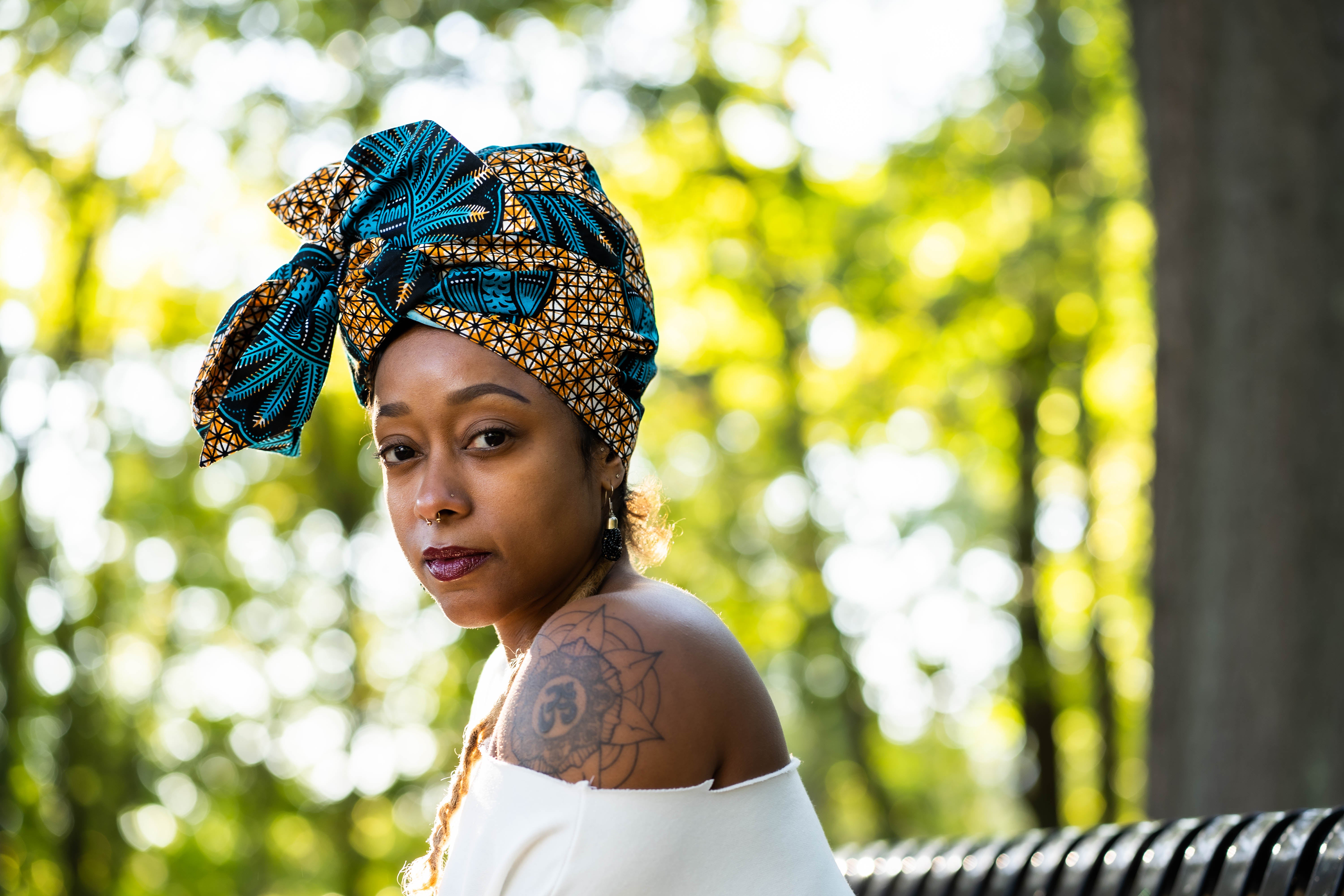 Woman wearing a decorative headscarf in a park setting